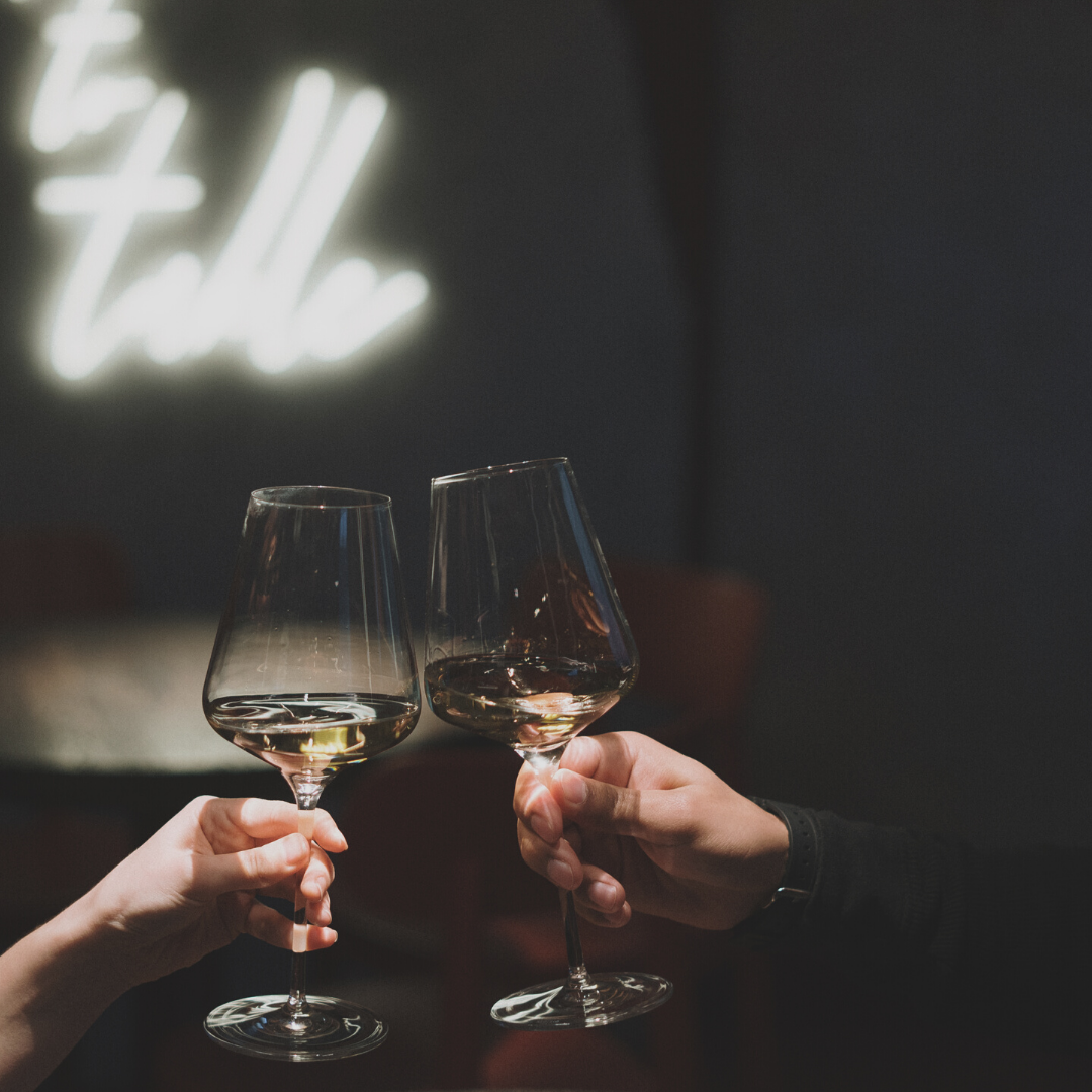 Two wine glasses clinking | About Last Night signature candle from Happy Little Flame